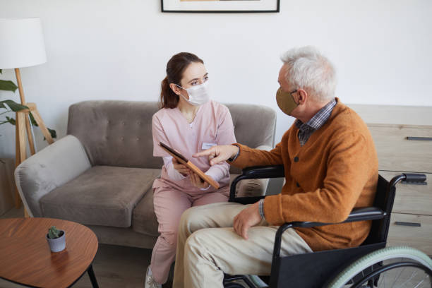 enfermeira mulher ajudando idoso deficiente com tecnologia - home caregiver senior adult community outreach nursing home - fotografias e filmes do acervo