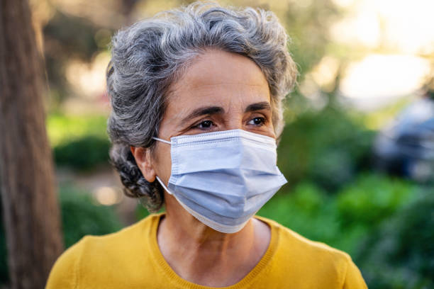 istock Senior woman wearing a protective mask and smiling 1307244494