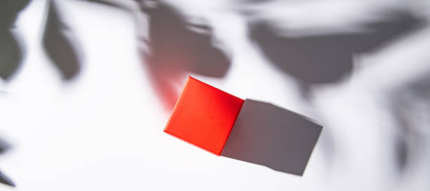 istock red gift box on white table with morning  shadow. Top view and copy space. 1307245210