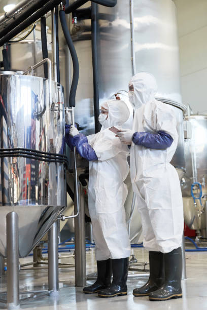istock Workers Wearing Hazmat Suits at Chemical Production 1307245465