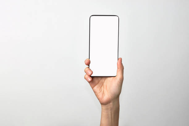 istock Woman hand holding phone on white background with copy space 1307245802