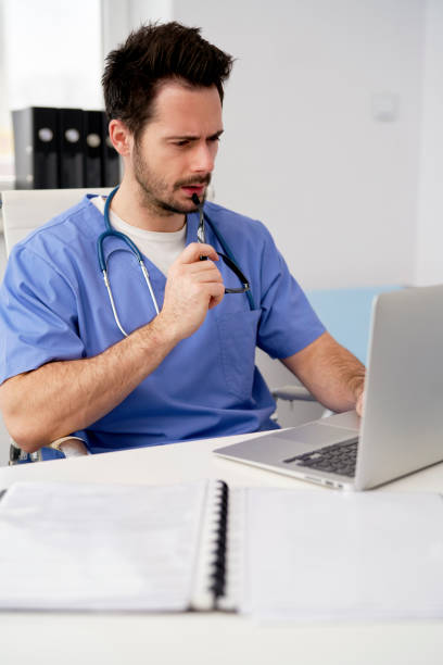 istock Focused doctor using laptop in doctor's office 1307245854