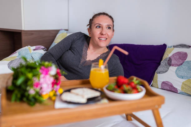 istock Happy young woman resting and getting breakfast in bed 1307246902