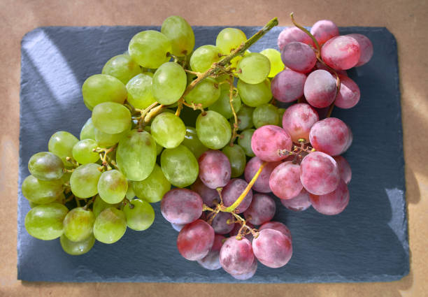 istock Bunches of white and red grapes on dark slate 1307251566