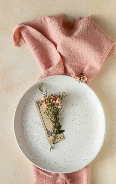 istock Romantic, wedding or spring table setting. Empty plate with card and little pink flowers, light concrete background. 1307251668