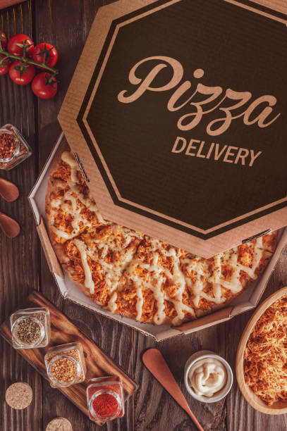Brazilian pizza with mozzarella, chicken, catupiry and oregano  in a delivery box (Pizza de frango com Catupiry) - Top view.