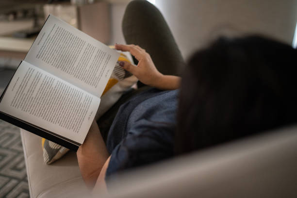 istock Mature woman reading a book at home 1307257301
