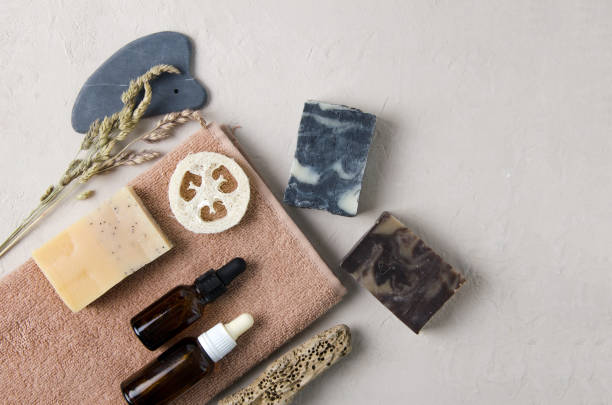 Cosmetic accessories for body, hand, face care. On the towel lies natural soap, natural serum in glass bottles with a pipette, natural stone guache, a washcloth. Natural cosmetics concept flat lay, copy space accesorios cosméticos para el cuidado del cuerpo, la mano, la cara. en la toalla se encuentra jabón natural, suero natural en botellas de vidrio con una pipeta, guache de piedra natural, un paño de lavado. concepto de cosméticos naturales flat lay, esp