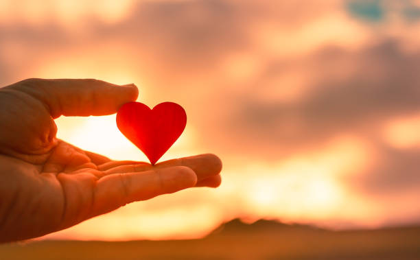 istock Hand holding heart at sunset. 1307265304