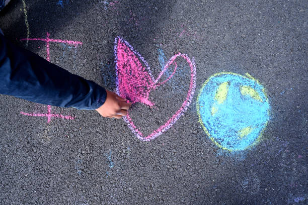 Philadelphia, PA, USA - April, 24, 2015; Child draws a heart on a schoolyard during Earth Day, in Philadelphia.
