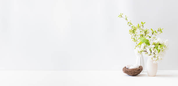 istock Home interior with easter decor. Spring flowers in a vase on a light background 1307266745