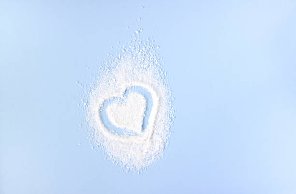 Heart made of white salt on blue background. Space for text.
