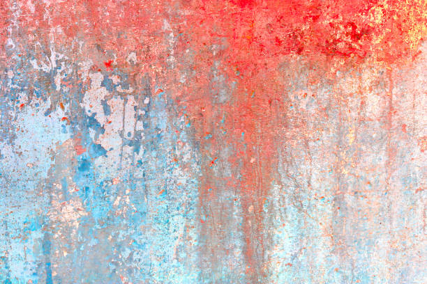 Old concrete wall covered with colorful paint. Background red blue and yellow spots on cracked stucco.