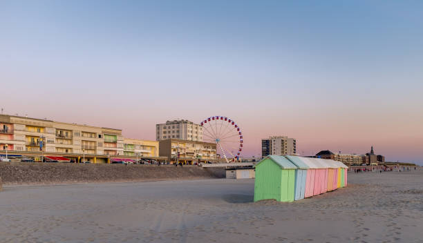 Pastel colored beach cabins and giant wheel along the Opal Coast in the North of France. Pastel colored beach cabins and giant wheel in Berck-sur-mer along the Opal Coast in the North of France. beach hut photos stock pictures, royalty-free photos & images