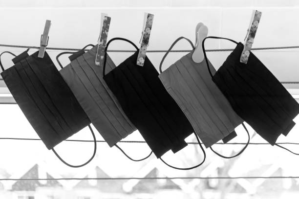 istock Back lit reusable face masks hanging on the wash line in a laundry room 1307274741