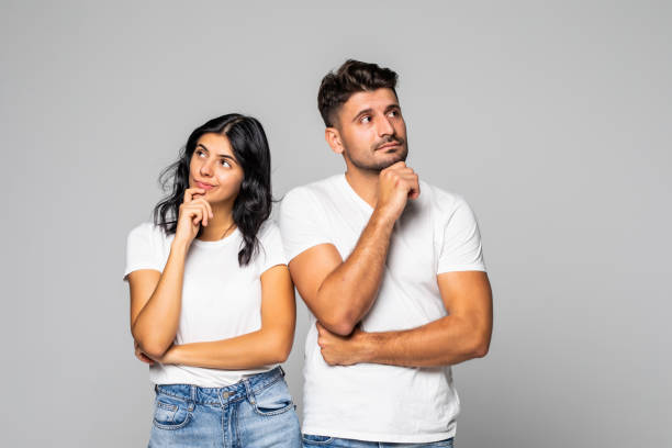 istock Young couple thinking over isolated white background 1307274805