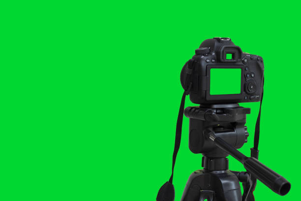dslr камера с зеленым экраном на штативе изолированы на зеленом фоне. зеленый экран камеры - chroma key flash стоковые фото и изображения