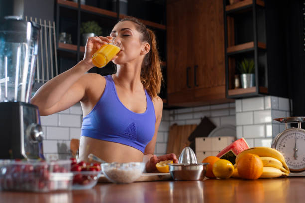Young woman drinking smoothie and rerlaxing after running stock photo