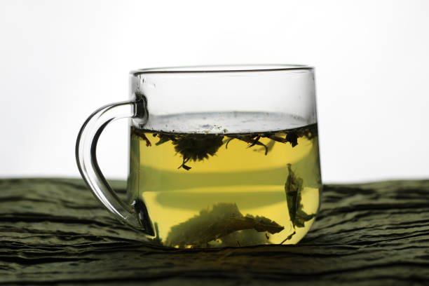istock Glass cup with herbal tea on wooden table with white background 1307278355