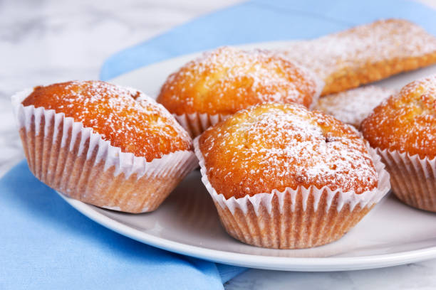 istock Closeup of mini muffins with icing sugar on white plate. 1307278786