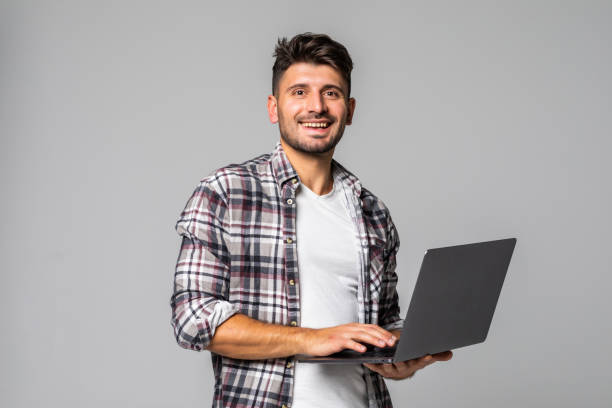 istock Smiling young man working on his laptop against white background 1307278928