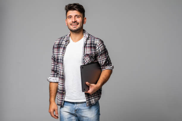 istock Smiling young man working on his laptop against white background 1307279640