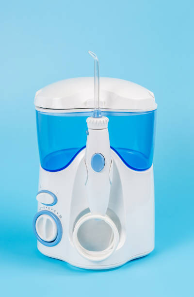 istock Electronic Tooth Irrigator for personal home usage on blue background. The concept of proper oral care, caries hygiene. 1307280099