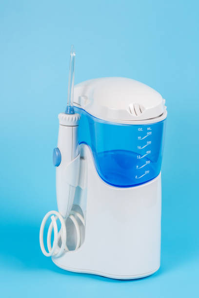 istock Electronic Tooth Irrigator for personal home usage on blue background. The concept of proper oral care, caries hygiene. 1307280110