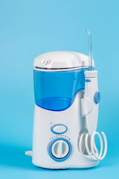 istock Electronic Tooth Irrigator for personal home usage on blue background. The concept of proper oral care, caries hygiene. 1307280113