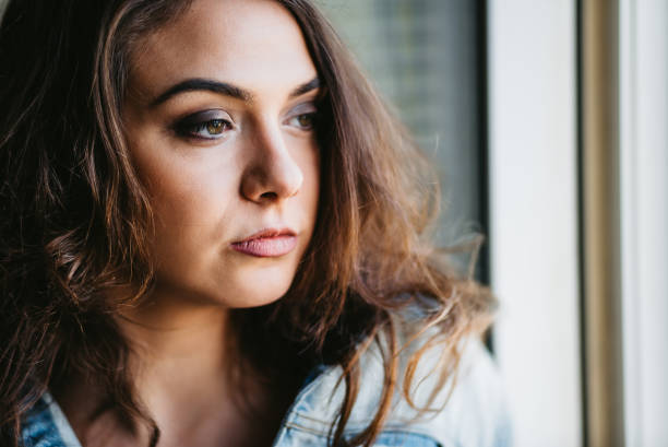 istock Woman standing next to window and relaxing 1307281262