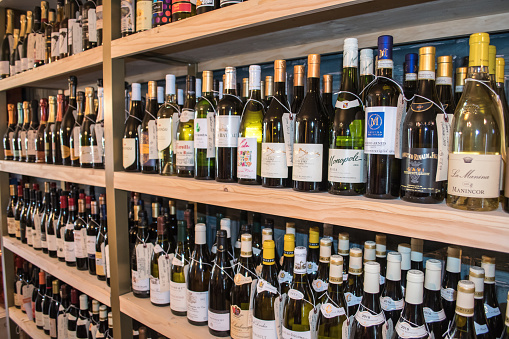 Small business, wine shop, tasting room, rows of shelves with wine bottles