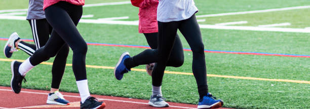 istock Side view of four runners wearing spandex running on a track 1307281983