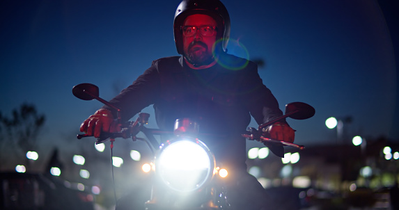 A lone motorcyclist looks right while riding at night in Ventura County, California.