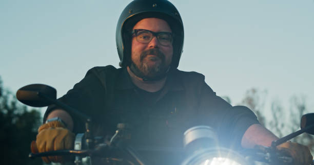 istock Lone Motorcyclist Looks Down and Smiles While Riding 1307283142