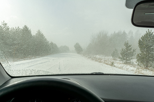Driving through a blizzard, view through a car window