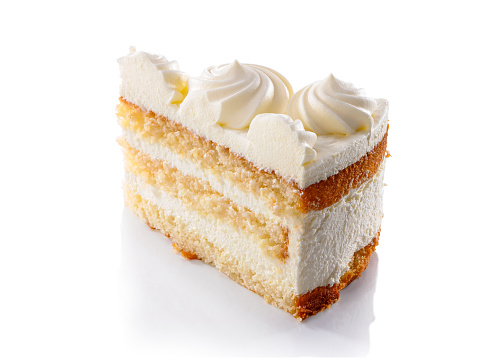 slice of layered sponge cake with whipped cream decoration close-up isolated on white background
