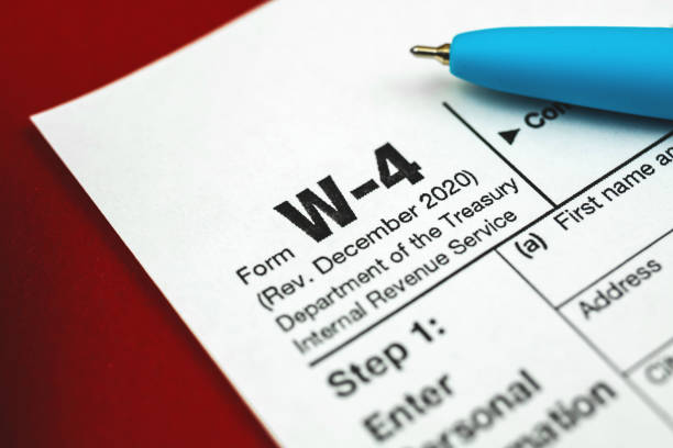 istock W-4 tax witholding form close up background with pen 1307286532