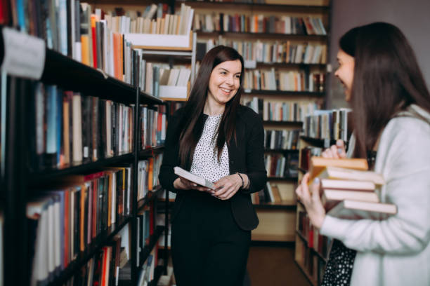 istock Two female students read and learns by the book shelf at the library 1307288143