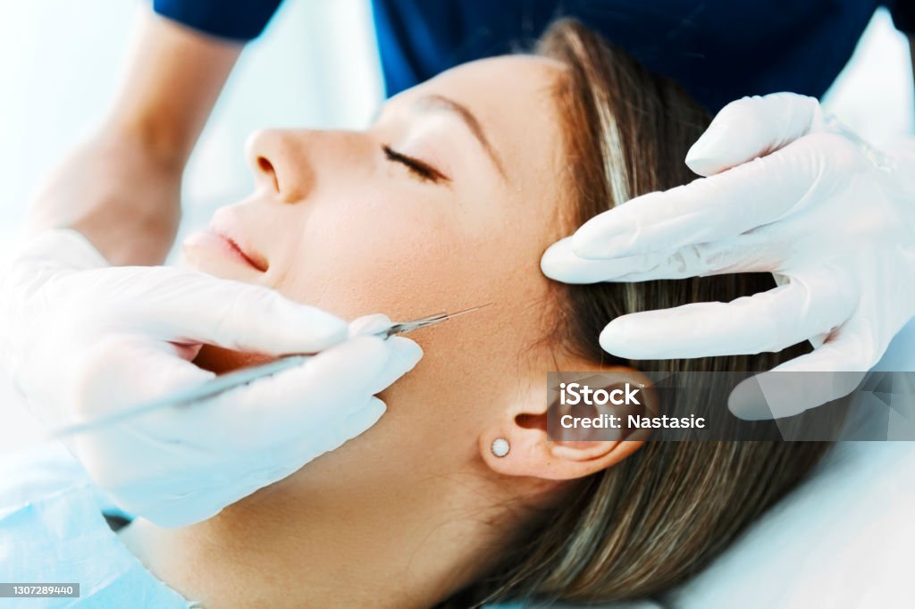 Esthetic surgery Young woman during surgery using a scalpel Scalpel Stock Photo
