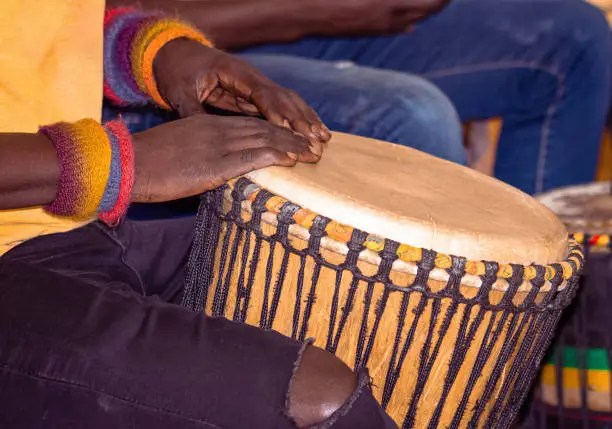 Close up of an African djembe drummer. Drummer playing African percussion music. Ethnic percussion musical instrument Djembe and male hands. Rhythm of Africa.