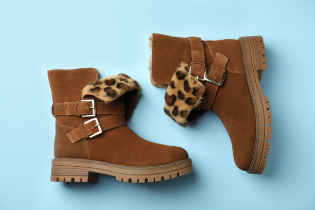 istock Stylish brown boots on light blue background, top view 1307291441