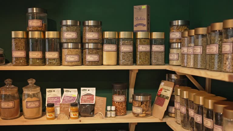 Labeled jars of different dried tea on the shelf at the modern health food store shop