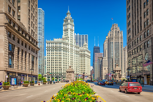 Cars and pedestrians move past ornate facades on Michigan Avenue in downtown Chicago,USA on a sunny day.