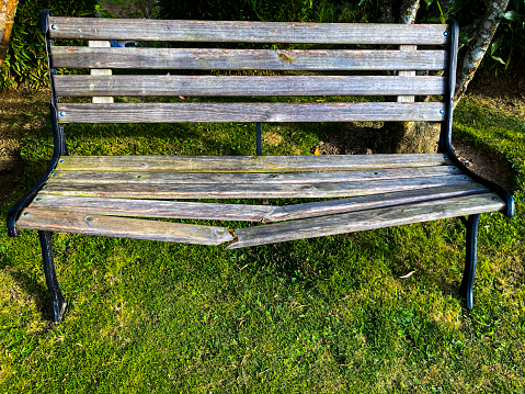 old wooden weathered bench near stone wall