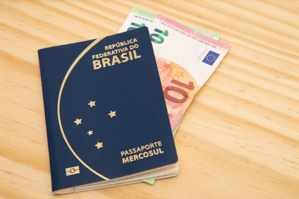 istock Passport with 110 euros inside, on a wooden table. 1307298963