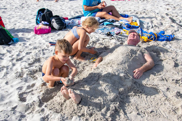 happy family having fun together on the beach at sunset. Building sand castle horizontal view.