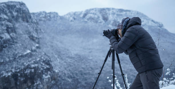 istock Photographer capturing a beautiful view on mountain with camera 1307300897