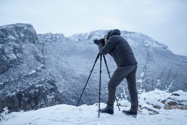 istock Photographer capturing a beautiful view on mountain with camera 1307300918