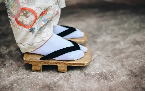 Photo of Close up of Japanese woman standing while wearing traditional Japanese footwear (called 'Geta').