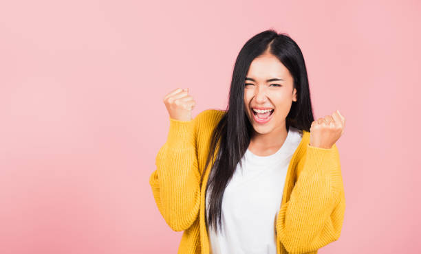 istock woman standing winning and surprised excited screaming 1307312020